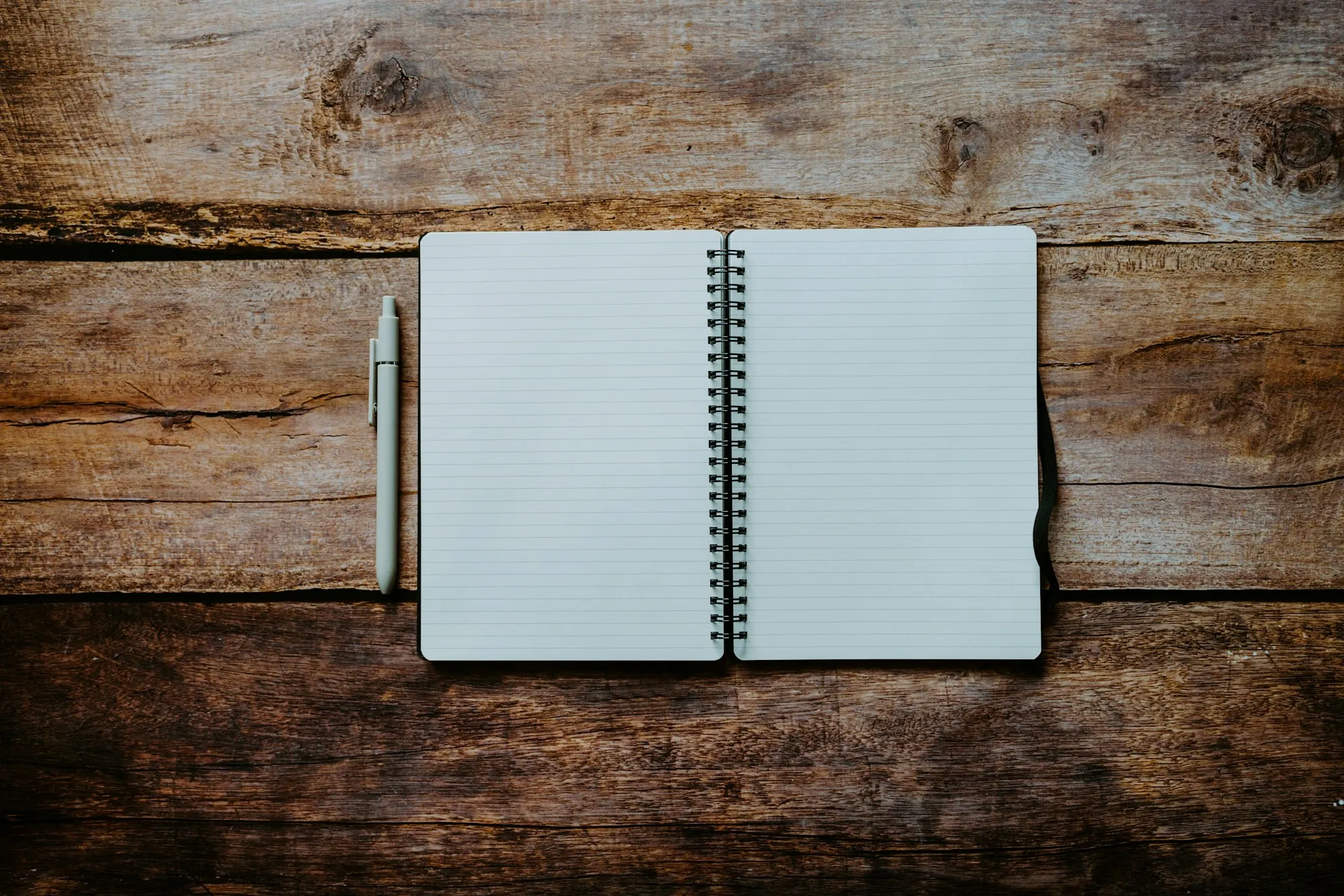 A notebook and pen on a wooden table