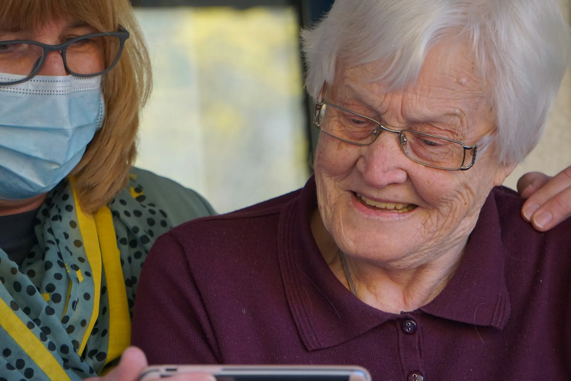 A care worker in a polo shirt and glasses